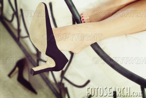 Close up of dangling black pump. Is she wearing toeless pantyhose?
